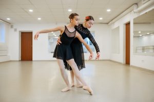 Choreographer works with young ballerina in class